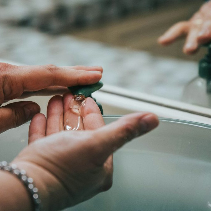 Na snímke si osoba umýva ruky v umývadle tekutým mydlom.