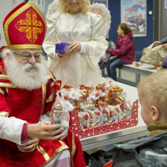 Na snímke Mikuláš rozdáva deťom darčeky. V pozadí čert a anjel.