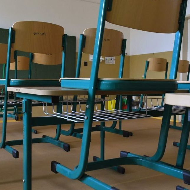 Ilustračná snímka školských lavíc v prázdnej triede.