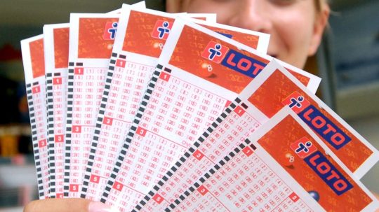 Žena drží žreby LOTO.