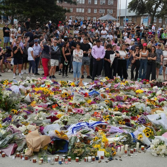 Ľudia kladú kvety na pamiatku obetí po hromadnej streľbe na pláži v Sydney.