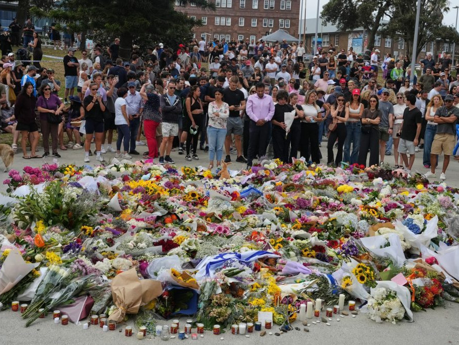 Ľudia kladú kvety na pamiatku obetí po hromadnej streľbe na pláži v Sydney.