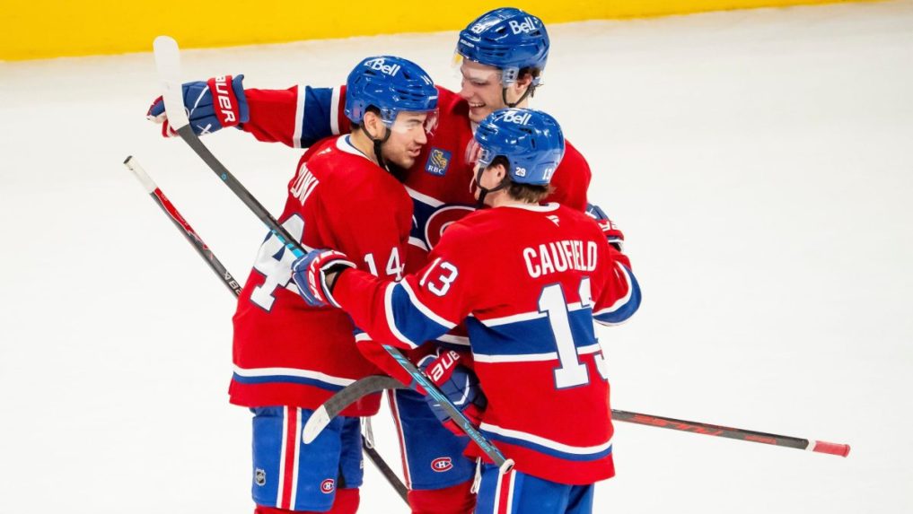 Hráč Montrealu Canadiens Nick Suzuki oslavuje so spoluhráčmi Jurajom Slafkovským a Coleom Caufieldom.