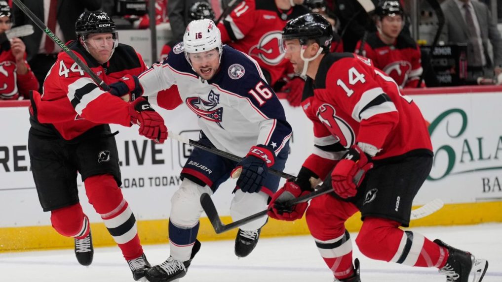 Útočník Columbusu Blue Jackets Brendan Gaunce (v strede) a hráč New Jersey Devils Dennis Cholowski.