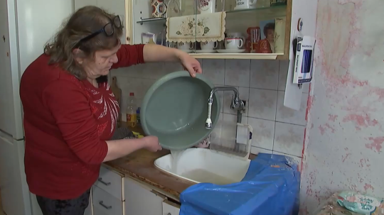 Na snímke žena vylieva vodu do umývadla.