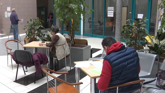 Na snímke ľudia vypisujú tlačivá.