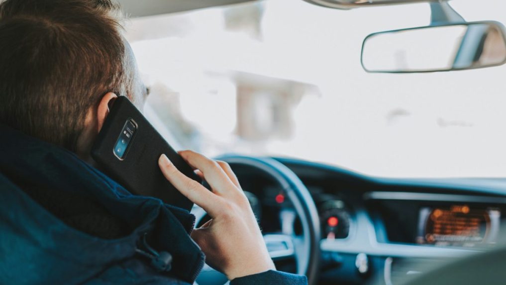 Na snímke muž telefonuje za volantom.