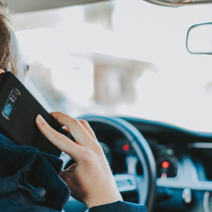 Na snímke muž telefonuje za volantom.