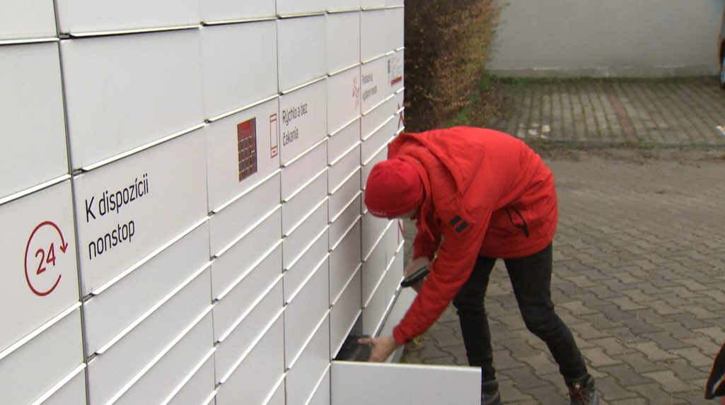 Kuriér vkladá balík do balíkoboxu