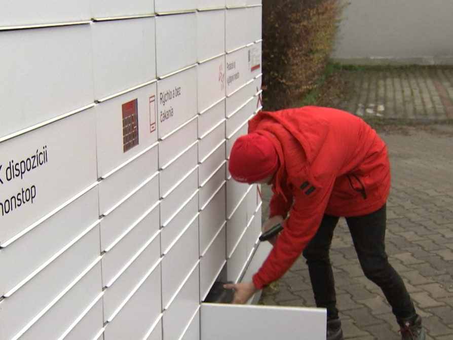 Kuriér vkladá balík do balíkoboxu