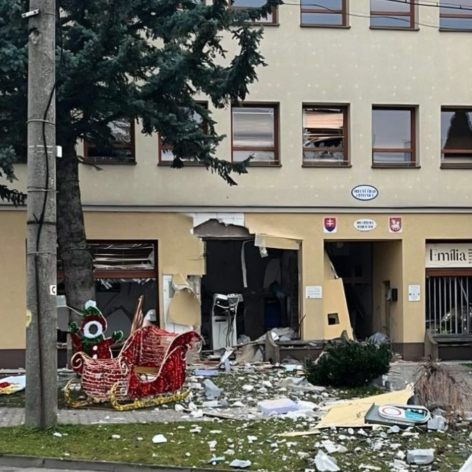 Na snímke poškodená budovať a bankomat po výbuchu.