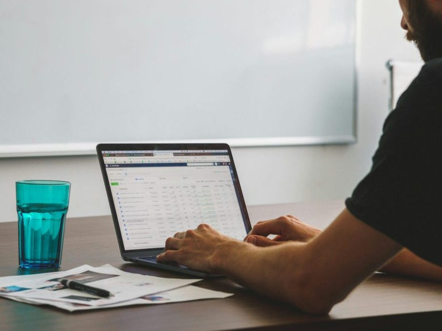 Ilustračná snímka muža pracujúceho na počítači.