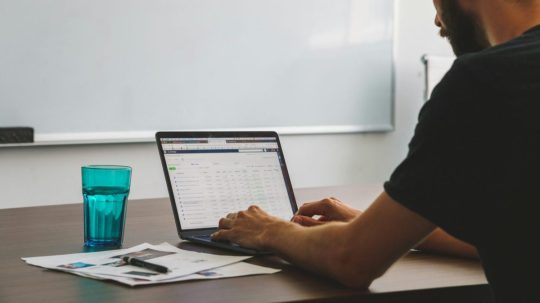 Ilustračná snímka muža pracujúceho na počítači.