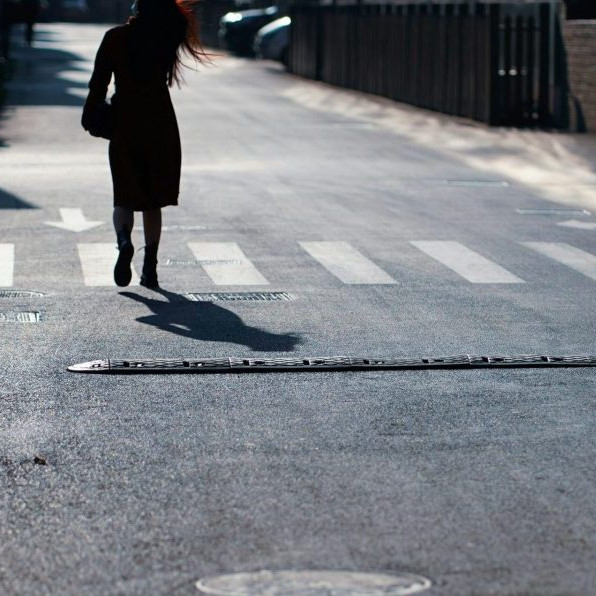 Na snímke sa žena prechádza po ceste.