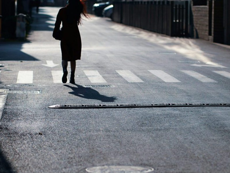 Na snímke sa žena prechádza po ceste.