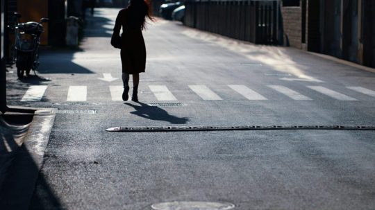 Na snímke sa žena prechádza po ceste.