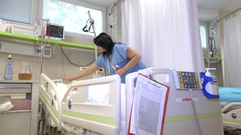 Na snímke je zdravotná sestra nad nemocničným lôžkom.
