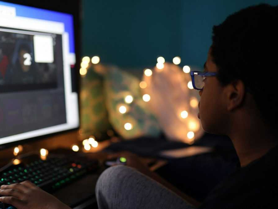 Dieťa sedí pred počítačom.