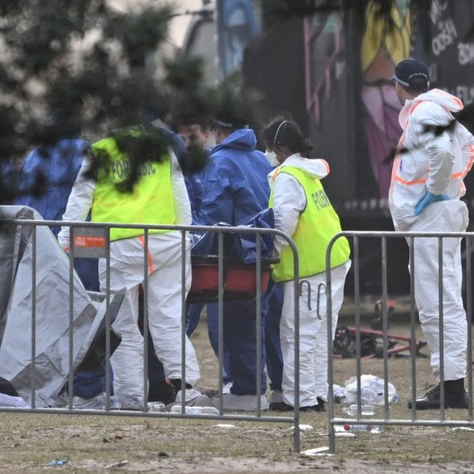 Forenzní technici skúmajú telo jednej z obetí streľby v Sydney.