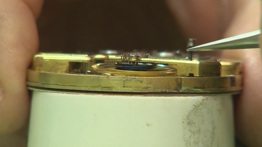 Hodinár opravuje hodiny.