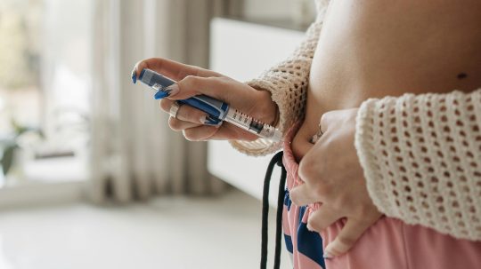 Žena si podáva inzulín injekciou pichnutím do brucha.