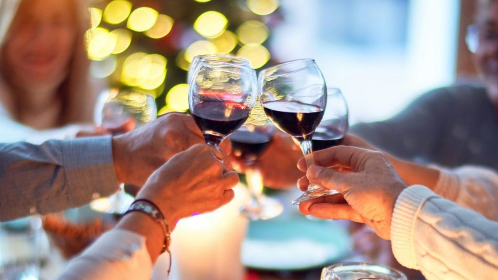 Na snímke si ľudia štrngajú pri večeri.