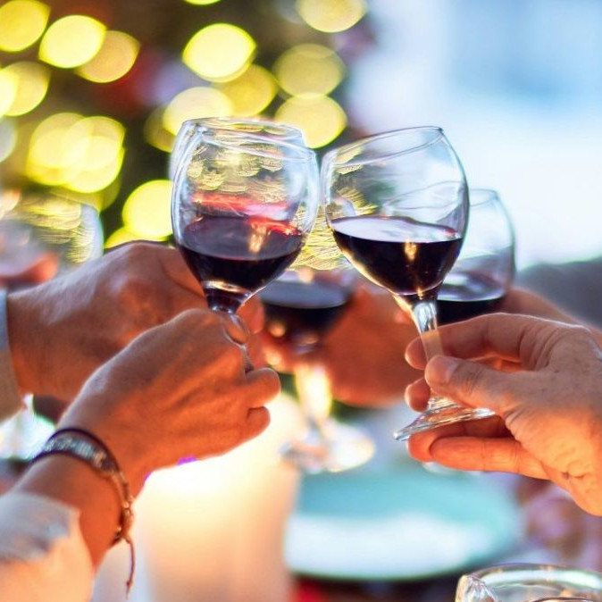 Na snímke si ľudia štrngajú pri večeri.