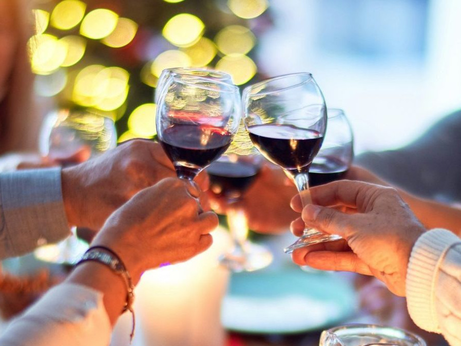 Na snímke si ľudia štrngajú pri večeri.