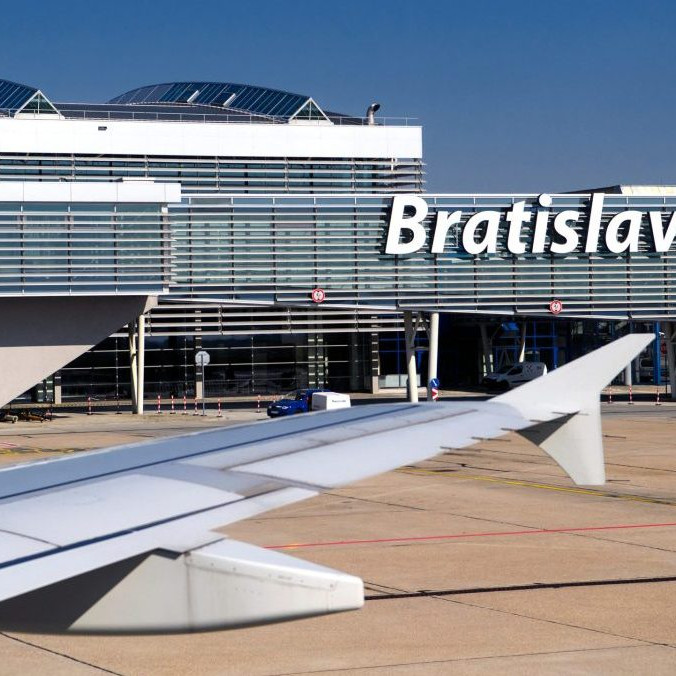 krídlo lietadla a budova bratislavského letiska