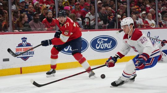 Na snímke slovenský hokejista v drese Montrealu Juraj Slafkovský (vpravo) a hráč Floridy Niko Mikkola.