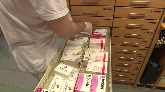Na snímke lekárnik vyberá zo zásuvky škatuľku liekov.