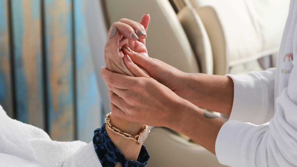 Na snímke ošetrovateľka drží ruku staršej osoby.