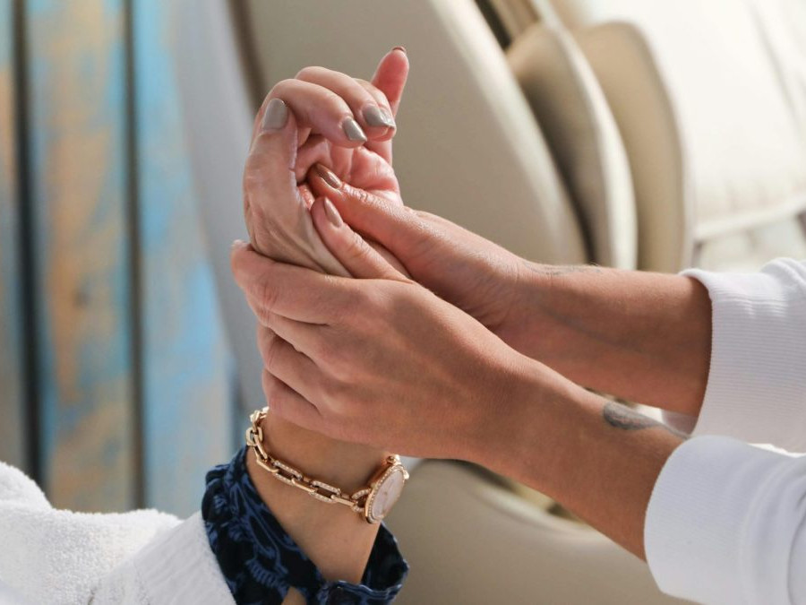 Na snímke ošetrovateľka drží ruku staršej osoby.