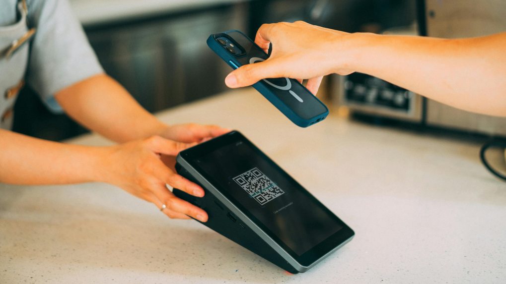 Osoba platí QR kódom.