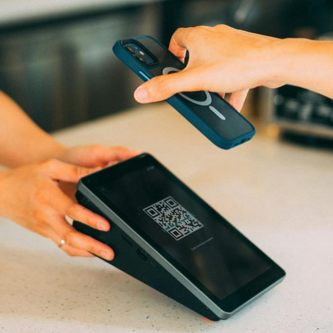 Osoba platí QR kódom.