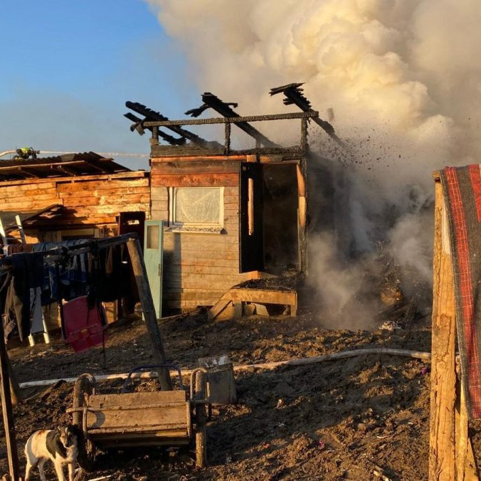 Požiar chatrčí v Arnutovciach. Z trosiek stúpa dym, zasahujú hasiči.