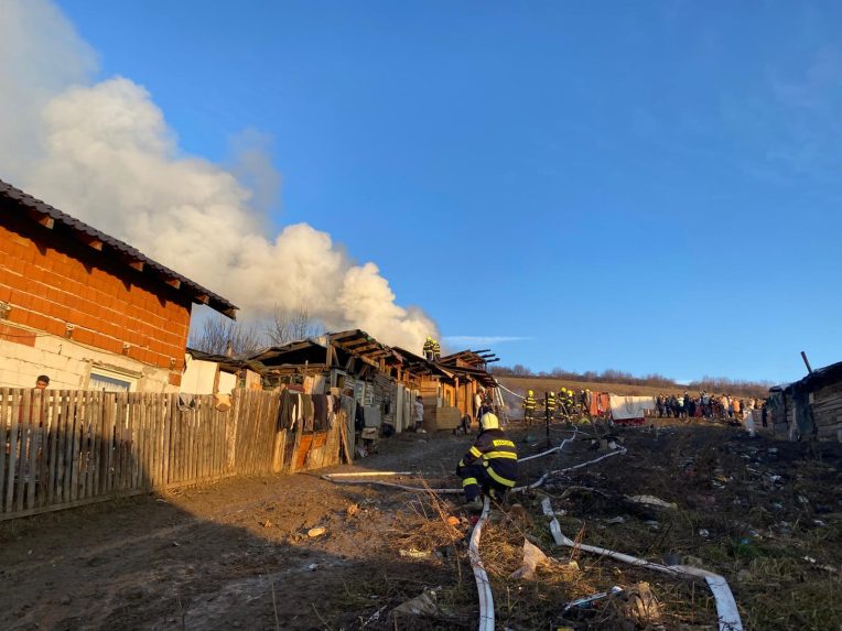 Požiar chatrčí v Arnutovciach. Z trosiek stúpa dym, zasahujú hasiči.