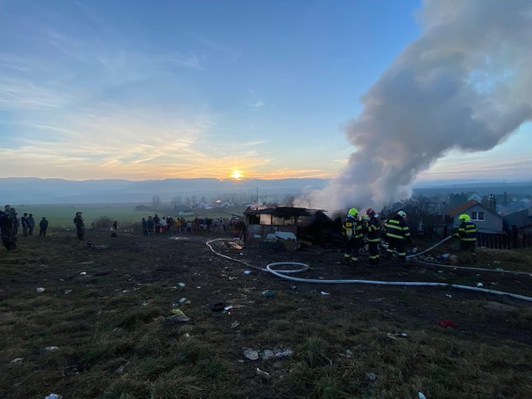 Požiar chatrčí v Arnutovciach. Z trosiek stúpa dym, zasahujú hasiči.