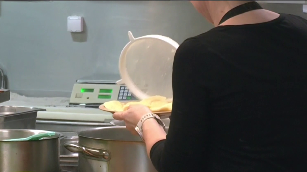 Žena v reštaurácii pracuje so sitkom a jedlom.