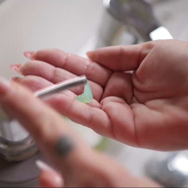 Na snímke žena si dávkuje mydlo do ruky.