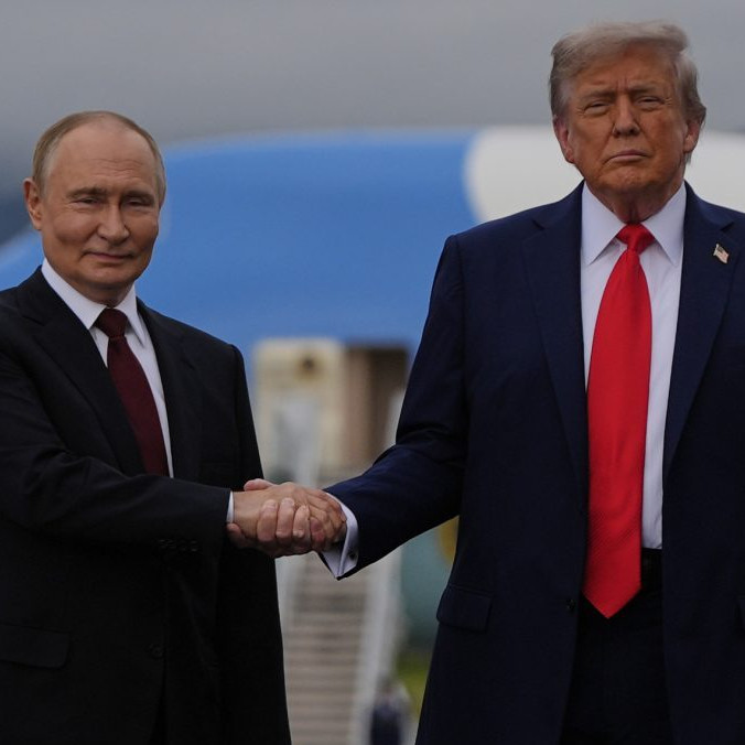 Na snímke Putin a Trump si podávajú ruky a pózujú fotografom.