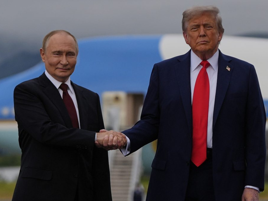 Na snímke Putin a Trump si podávajú ruky a pózujú fotografom.