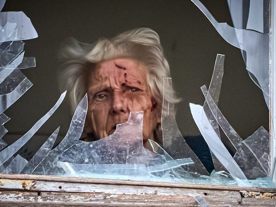 zranená žena za rozbitým oknom