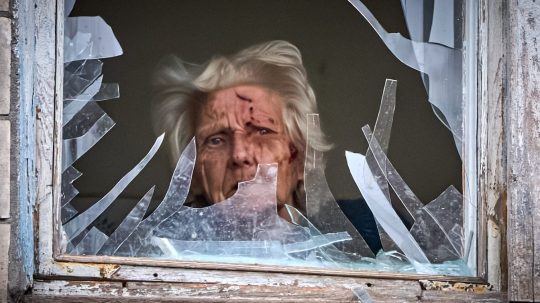 zranená žena za rozbitým oknom