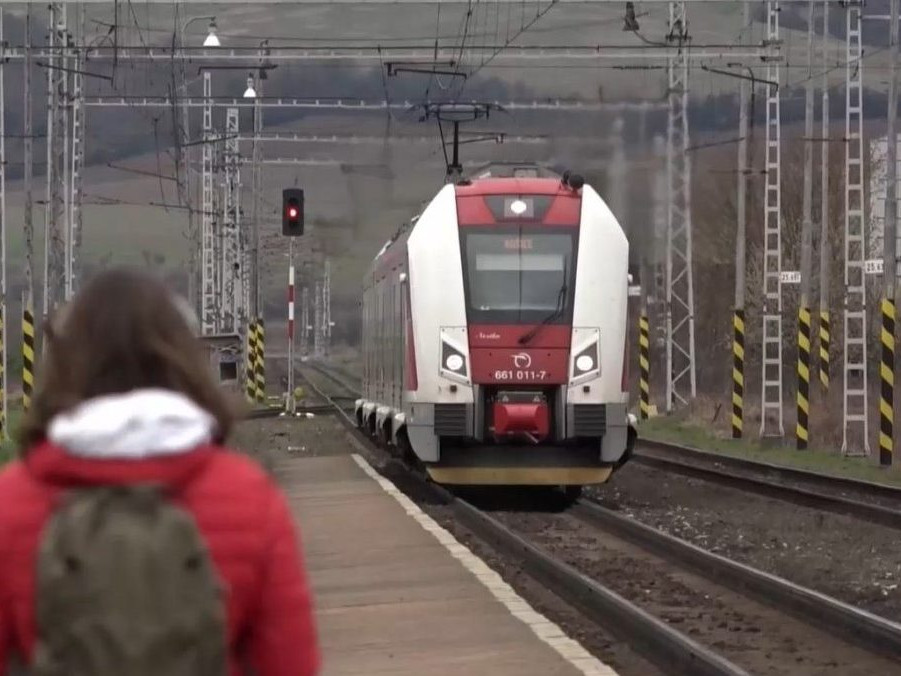 Na ilustračnej snímke žena a prichádzajúci vlak na železničnej stanici.