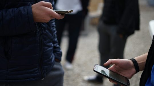 Na snímke tú tínedžeri s telefónmi.