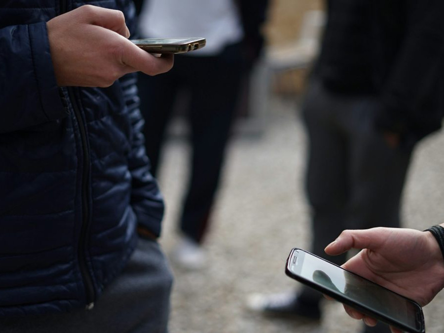 Na snímke tú tínedžeri s telefónmi.