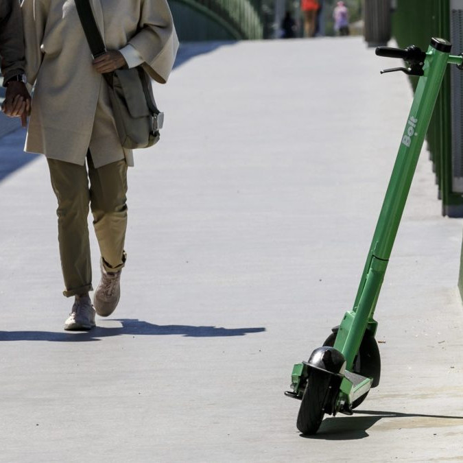 Na snímke elektrická kolobežka a dvojica chodcov.