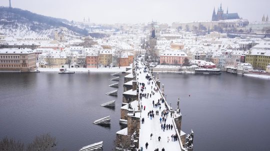 Zasnežený Karlov most v Prahe.