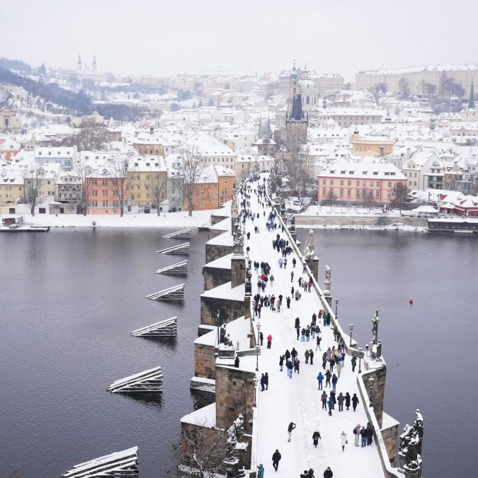 Zasnežený Karlov most v Prahe.